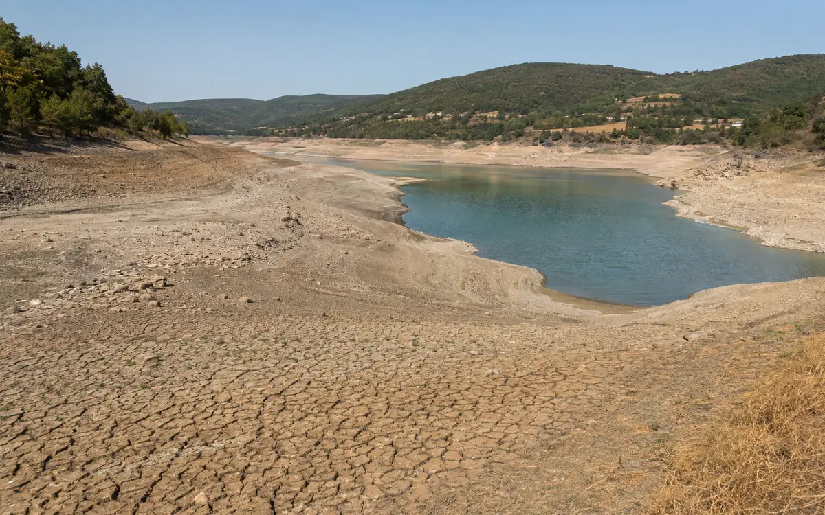 Sol marqué par la sécheresse au bord d’une retenue d’eau